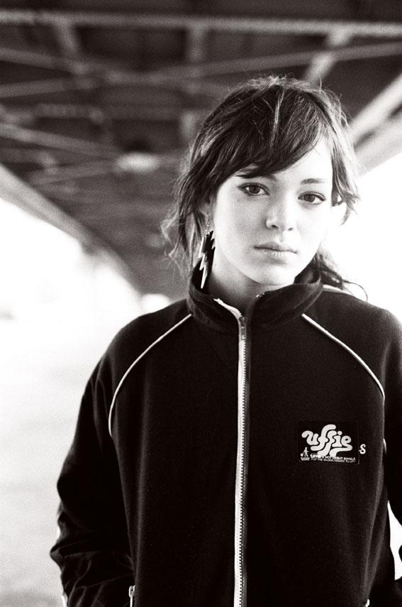 Portrait of Uffie in a dark track jacket with a lightning-bolt earring